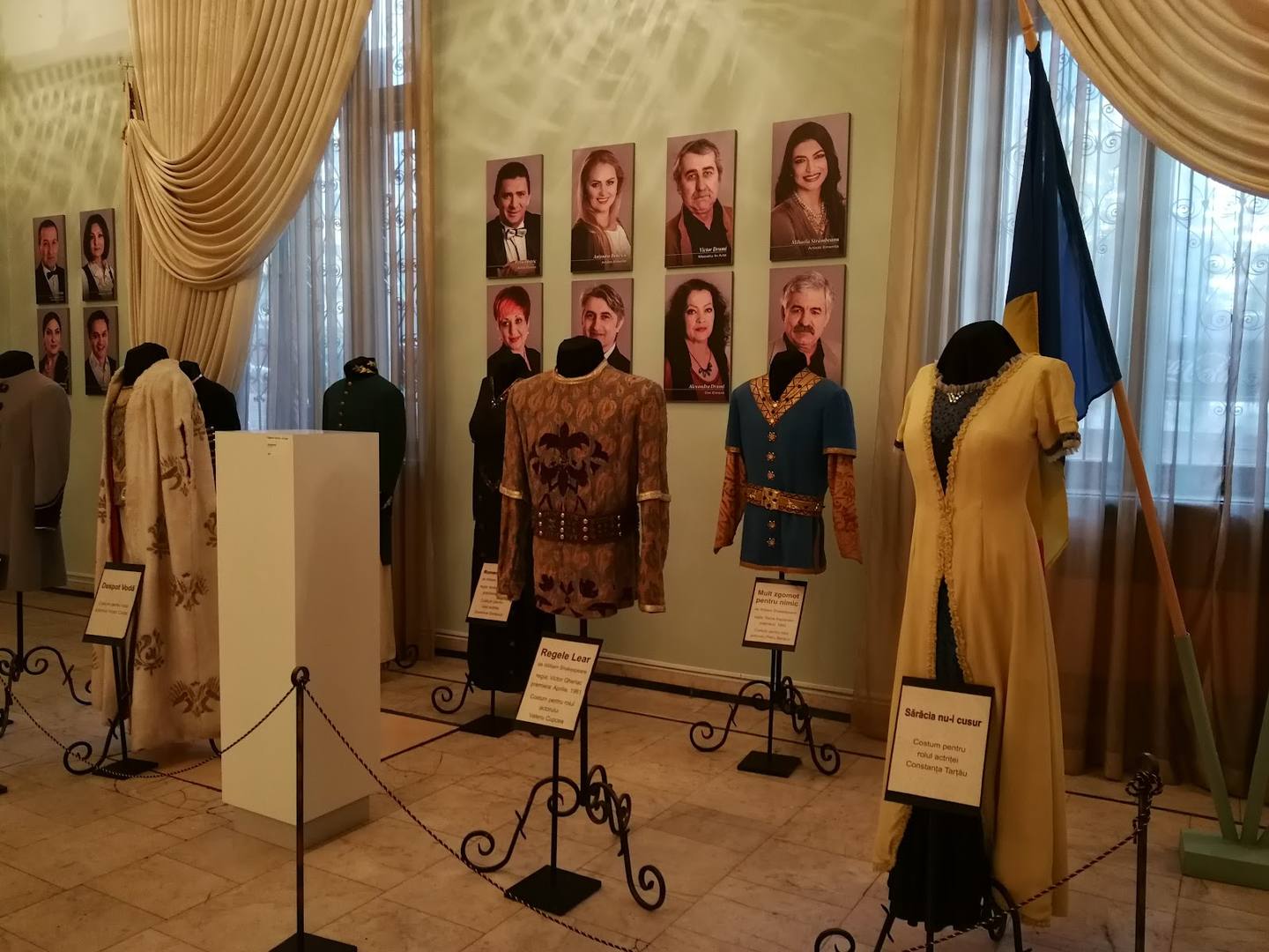 Fashion designer showroom with garment displays and portrait gallery on walls