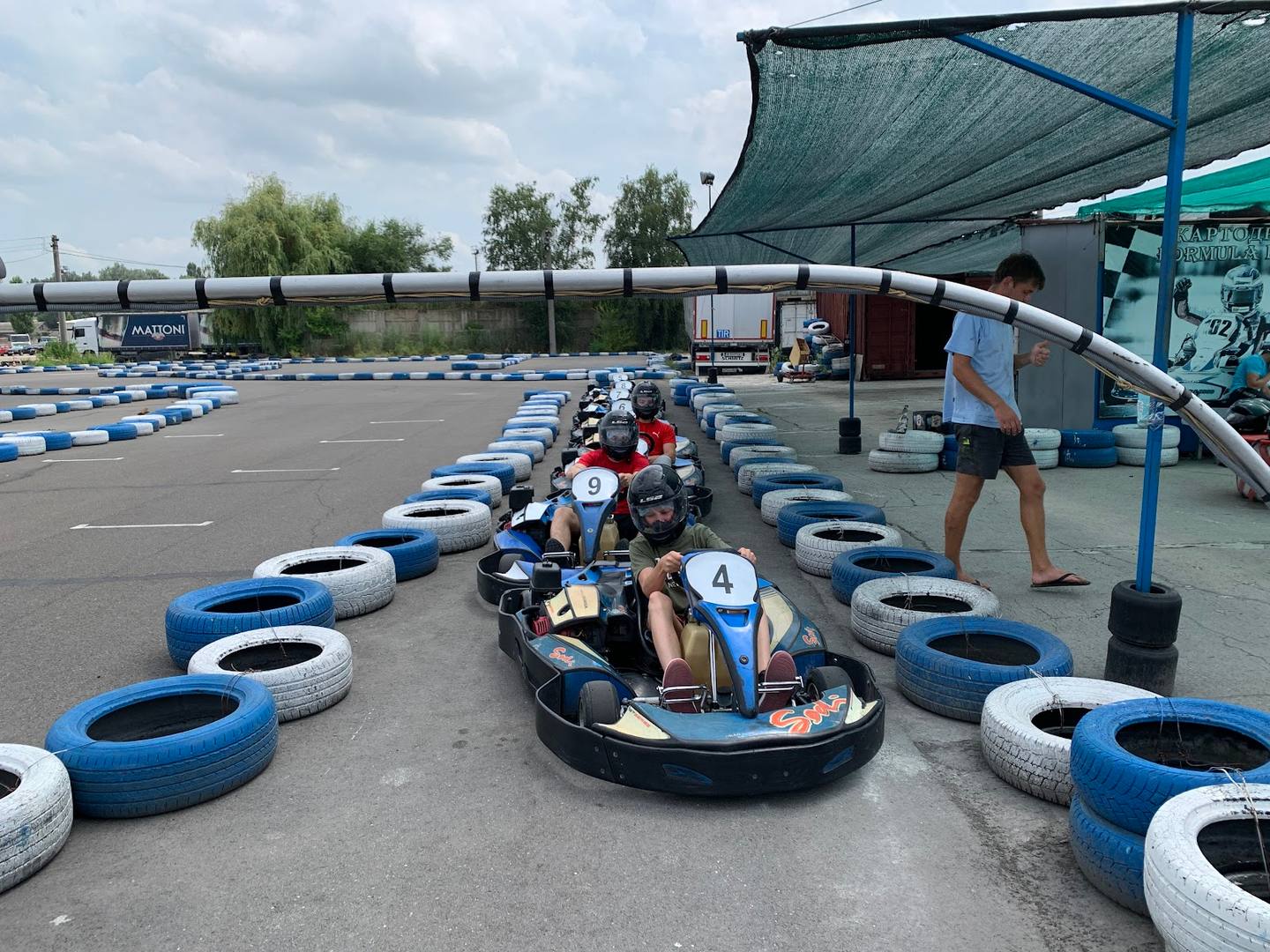 Go-kart racing track with blue and white tires and active driver on course