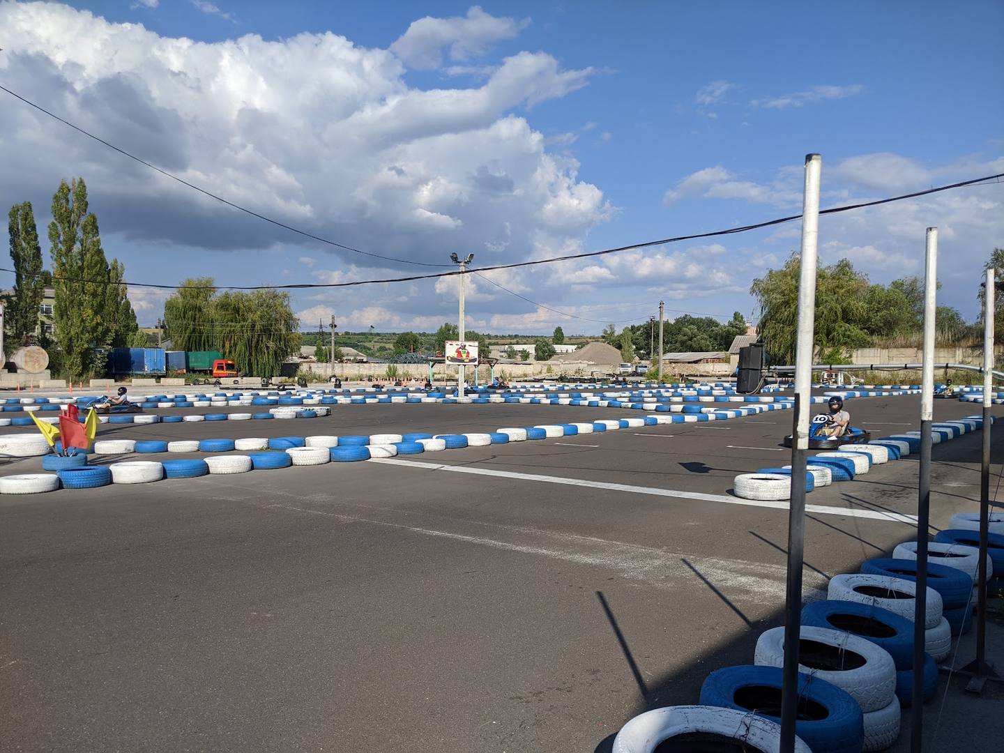 Go-kart racing track with painted lanes and barriers visible in daylight