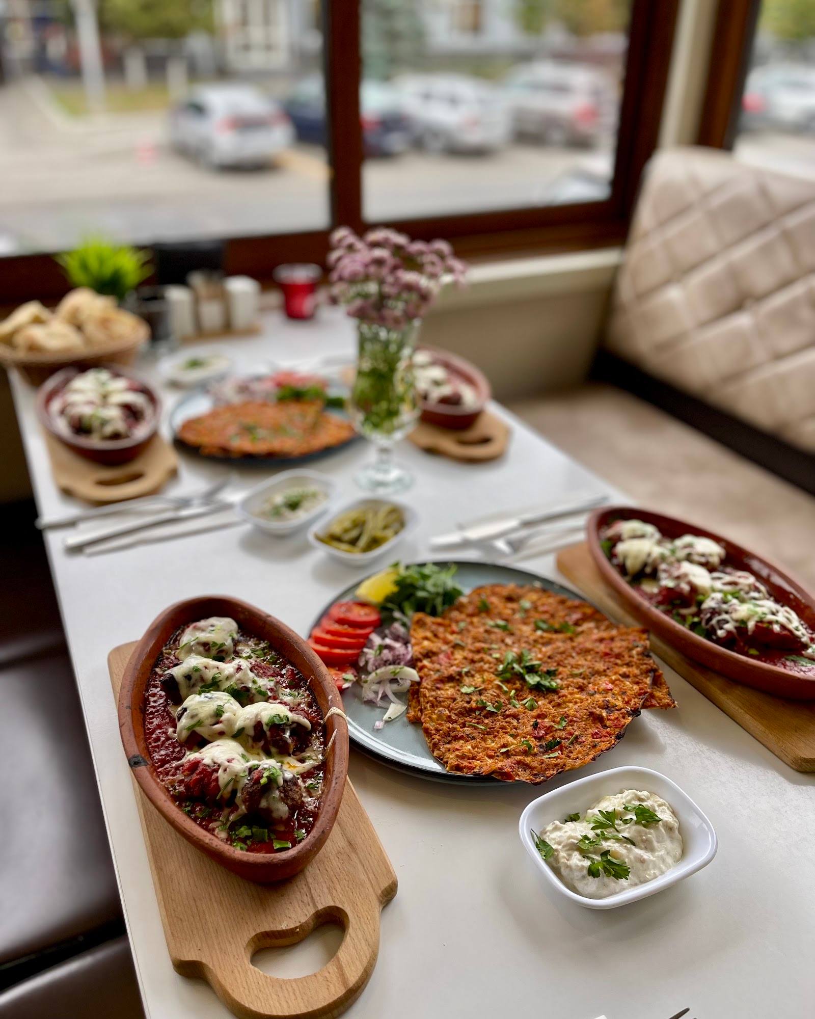 Plated Eastern European cuisine spread with appetizers and mains near window seating