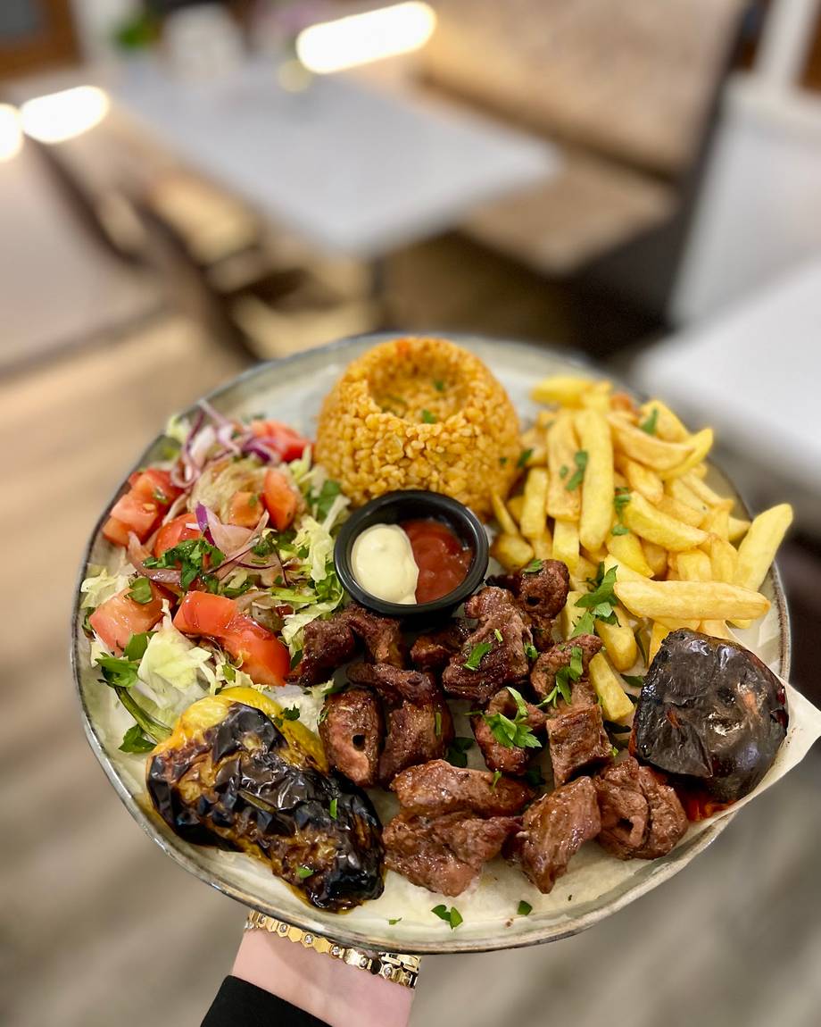 Mixed grill platter with salad, fries, grilled vegetables and sauce