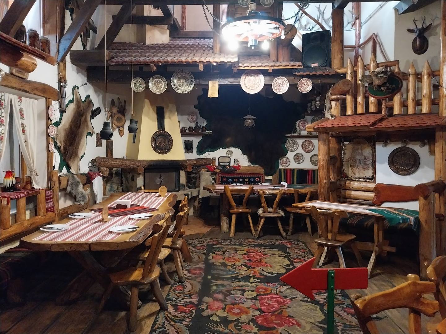 Rustic tavern interior with wooden furniture, vintage decor, and traditional cookware displays