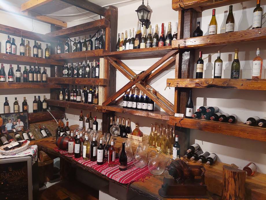 Rustic wine shop interior with wooden shelving displaying bottles and wine selection