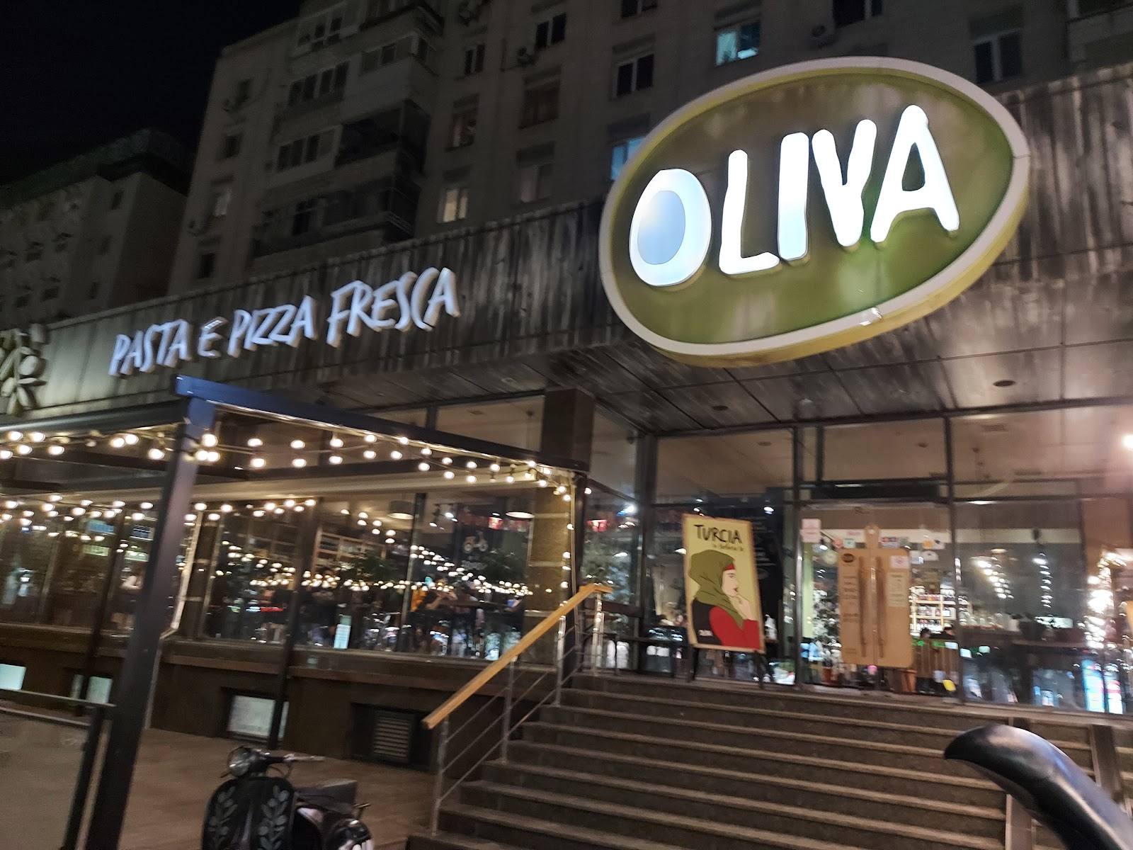 Oliva restaurant storefront with illuminated signage at night, pasta and pizza venue in Chisinau