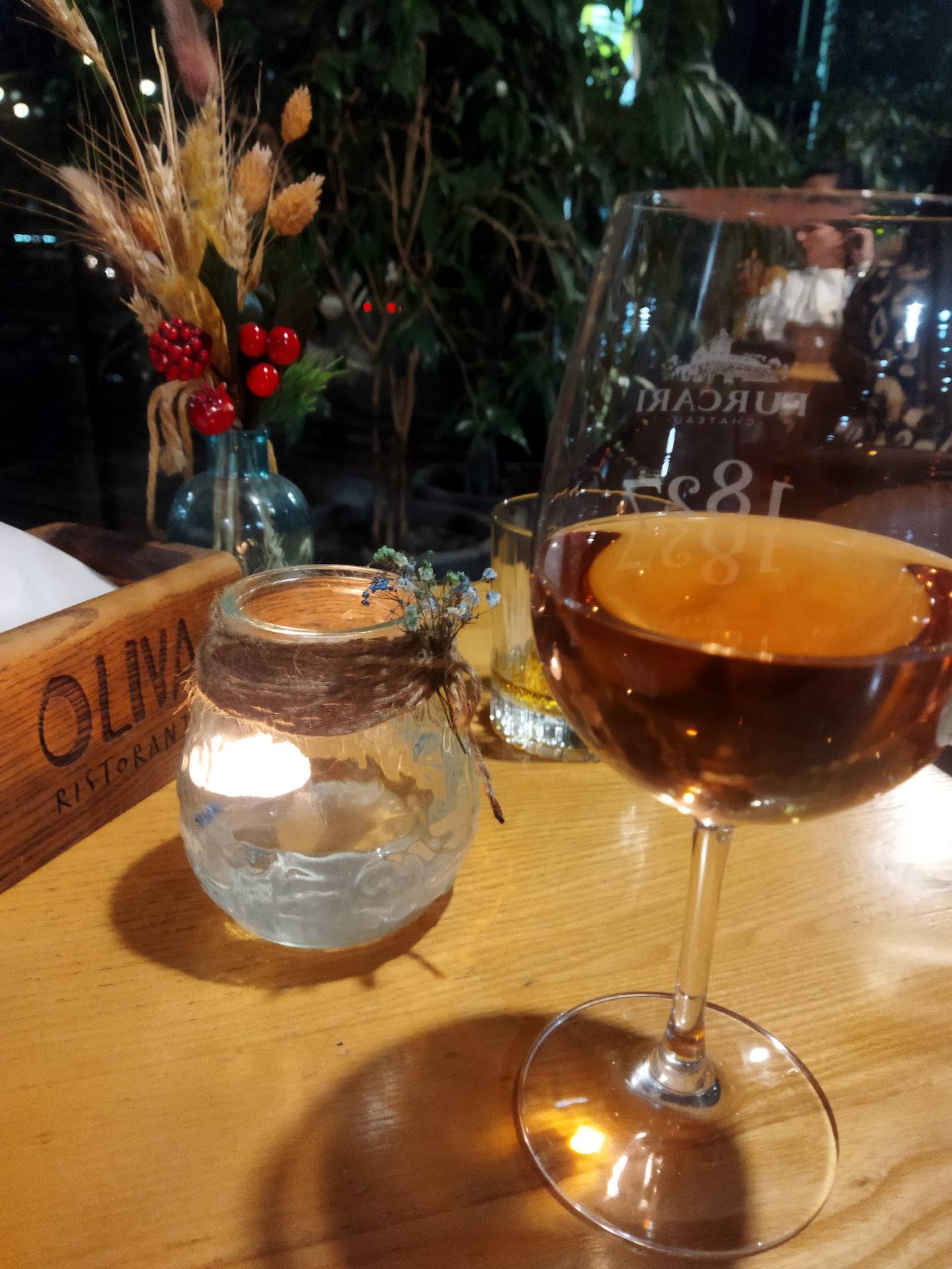 Amber cocktail with tablescape and ambient greenery at wine bar