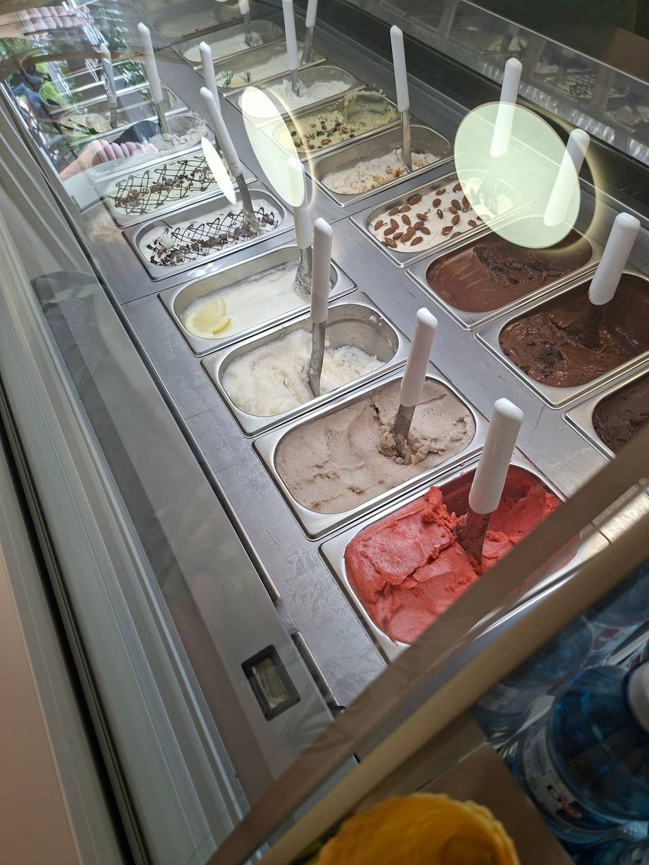 Ice cream gelato display case with multiple flavors in metal bins